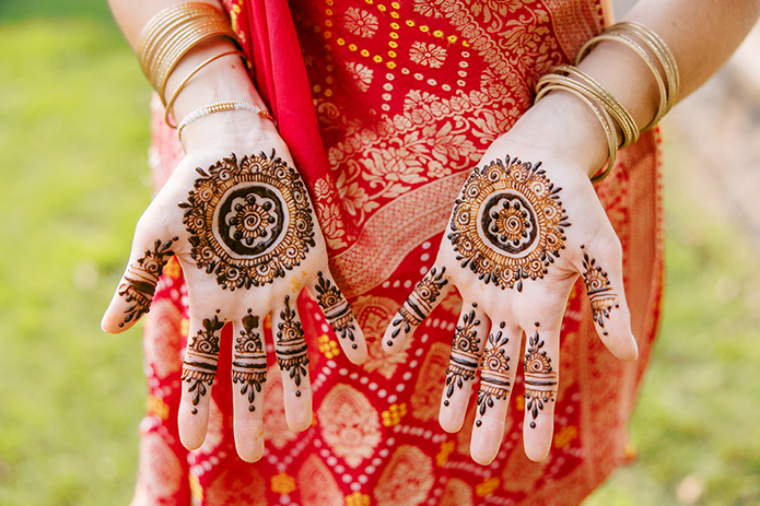 Sister of bride displaying henna design on the palms of her hands